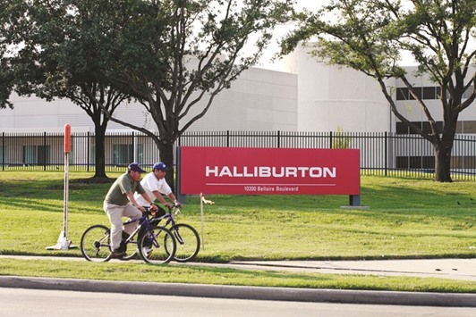 A pair of bicyclists ride past Halliburtonu2019s Energy Services Group, headquartered in West Houston (file). Halliburton has warned workers not to travel to the US if they are from any of the countries named in Trumpu2019s immigration ban signed last week.