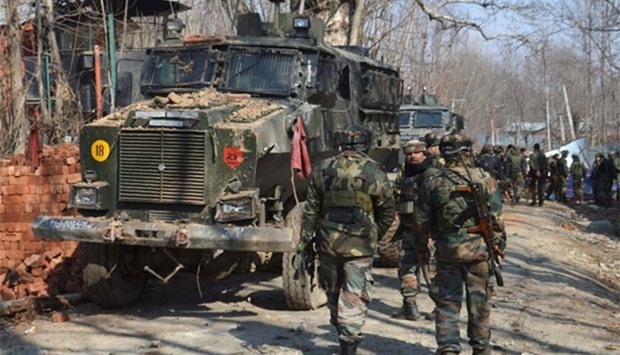 Indian security personnel walk through the scene of a firefight in Frisal village in Kulgam, some 70 kms south of Srinagar, on Sunday.
