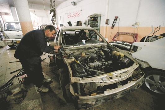 A worker fixes a car at an industrial neighbourhood of Mosul yesterday.