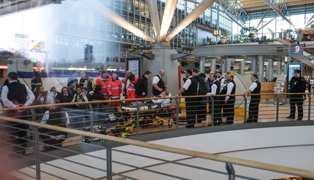 Firefighters take care of a person on a stretcher inside Hamburg airport in Hamburg, northern Germany, as German emergency services evacuated the airport after people reported an unusual smell as well as respiratory ailments and watering eyes.