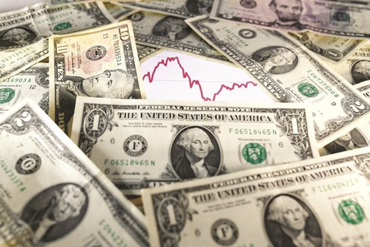 US dollar notes are seen in front of a stock graph in this November 7, 2016 illustration. Despite the significant appreciation of REER in the GCC and the large fiscal deficits, the authorities remain firmly committed to their dollar pegs, believing that the pegs safeguard economic stability, the IIF said.