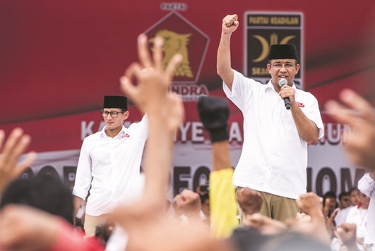 Anies Baswedan (right), a candidate in the running to lead the Indonesian capital Jakarta, and his deputy Sandiaga Uno stand in front of their supporters during campaigning in Jakarta, Indonesia.
