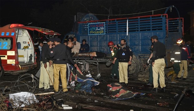 Pakistani policemen and volunteers at the site of a bomb explosion in Lahore