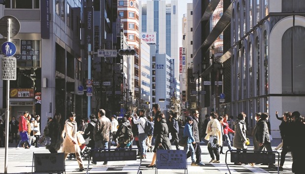 People walk on a street at Tokyou2019s Ginza shopping district. Japanu2019s economy grew an annualised 1% in October-December, roughly in line with the 1.1% increase markets had expected, following a revised 1.4% expansion in July-September, data showed yesterday.