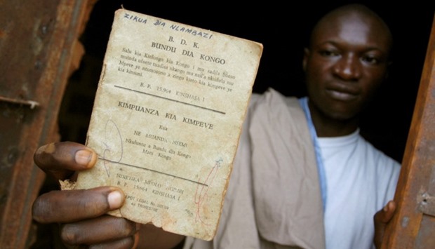 A resident holds up a Bundu dia Kongo manifesto left behind after a police crackdown on the religious and political movement in Matadi, capital of Democratic Republic of Congo's volatile Bas Congo province.  March 18, 2008 file picture.