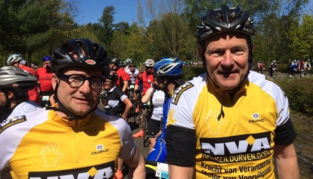 Ben Weyts (L) posing for a photograph along with a bike rider