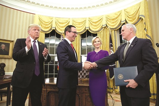 Mnuchin is congratulated by Vice-President Pence after being sworn in as Treasury Secretary in the Oval Office of the White House. With them are President Trump and Mnuchinu2019s fiancee Louise Linton.