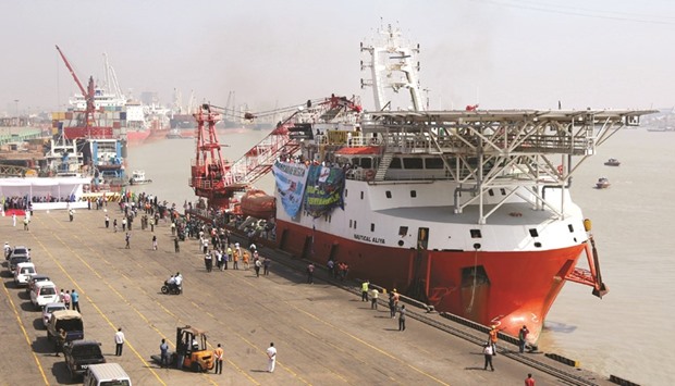 Workers look on as Malaysian ship Nautical Aliya, with relief aid for Rohingya, is unloaded as she sits moored at the port of Chittagong yesterday.