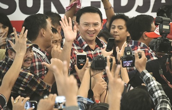 Incumbent governor Basuki Tjahaja Purnama (centre) meets supporters and the media after voting in local elections in Jakarta yesterday.
