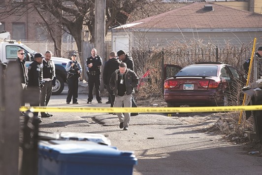 Police look over a bullet-riddled car after a gunman opened fire killing a two-year-old child, a man in his twenties and wounding a pregnant woman in the Lawndale neighbourhood on Tuesday in Chicago.