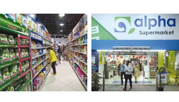 Employees check stock at the Alpha Supermarket under which Tesco products will be stocked in Karachi. Right: People walk out of the Alpha Supermarket under which Tesco products will be stocked in Karachi.