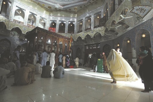 A woman clad in burqa walks in the hallway of the tomb of Lal Shahbaz Qalandar, in Sehwan Sharif, in Sindh province.