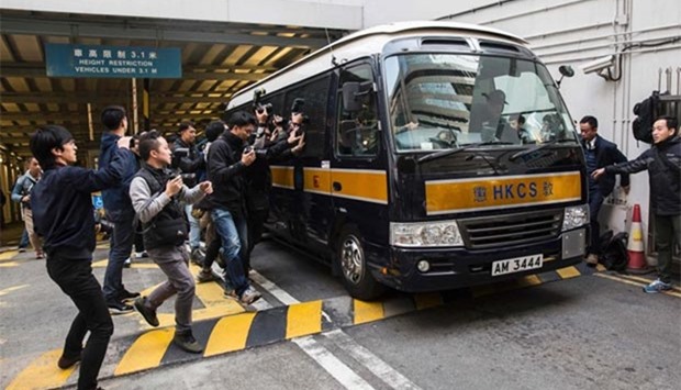 Media surround a prison van holding seven police officers as it leaves the District Court in Hong Kong earlier this week.