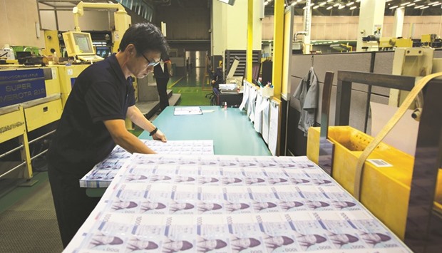 An employee inspects sheets of won banknote at the Korea Minting, Security Printing & ID Card Operating Corp factory in Geyongsan. The won is the best Asian emerging-market performer this year, strengthening 5.1% against the dollar.
