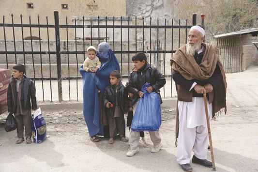 Afghan families wait to enter Pakistan at the Torkham border crossing yesterday.