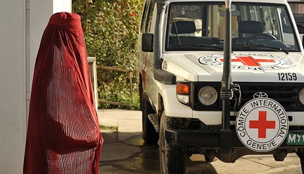Afghan pedestrain walks past a vehicle at the International Committee for the Red Cross