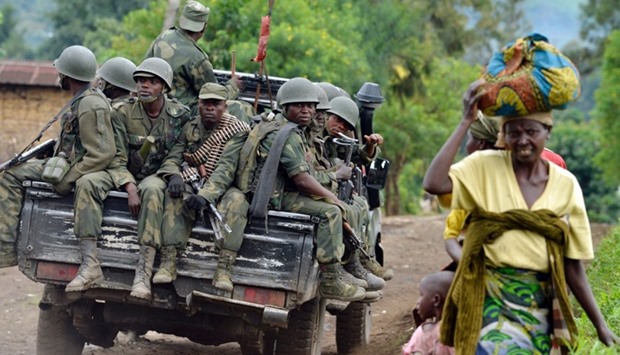 This file photo taken on November 4, 2013 towards the Mbuzi hilltop near Rutshuru shows Armed Forces of the Democratic Republic of Congo (FARDC) soldiers sitting at the back of a pick-up truck.