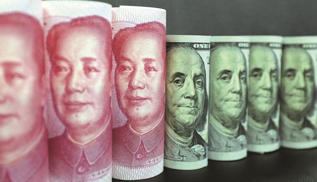 One hundred US dollar banknotes and 100 yuan banknotes are seen in Beijing. Chinau2019s reserves edged down to $2.998tn in January, falling to the lowest since early 2011 after the yuan capped its steepest annual drop in two decades.