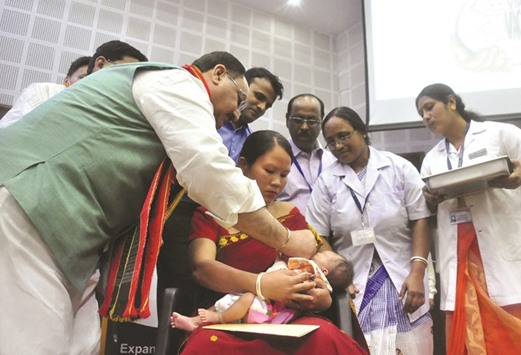 Federal Minister for Health and Family Welfare JP Nadda administers the Rotavirus vaccine to a child at Pragna Bhawan in Agartala.