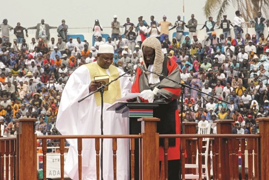 Barrow holds the Quru2019an during the swearing-in ceremony, presided by Chief Justice Hassan Jallow, at the Independence Stadium in Bakau.