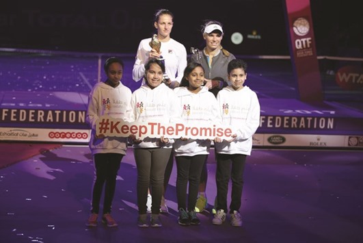 Young supporters of the programmeu2019s work pose for a picture with Qatar Total Open winner Karolina Pliskova and runner-up Caroline Wozniacki in Doha yesterday.