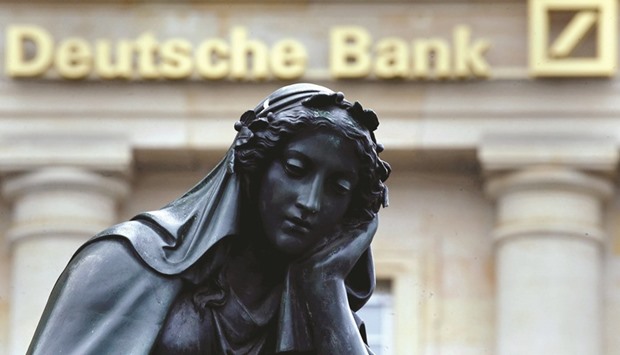 A statue is seen next to the logo of Germanyu2019s Deutsche Bank in Frankfurt. The bank should offer shares in its asset-management unit to the public rather than selling consumer lender Deutsche Postbank because itu2019s the more efficient way to improve capital levels, according to analysts at JPMorgan.