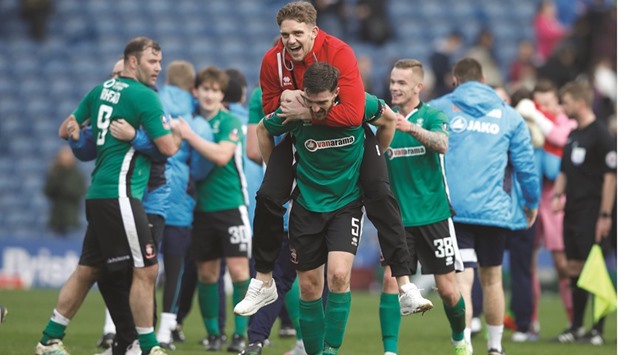Lincoln City players celebrate their historic win over Burnley yesterday. (Reuters)