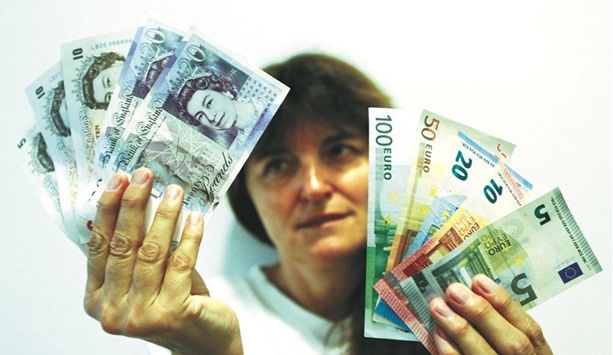 An employee holds British pounds and euro banknotes in a bank at the main train station in Munich. Falls for the euro and the pound dominated trade in the major global  currencies on Friday, hit by a combination of nerves over upcoming French elections and signs British consumers are beginning to struggle in the face of the Brexit effect.