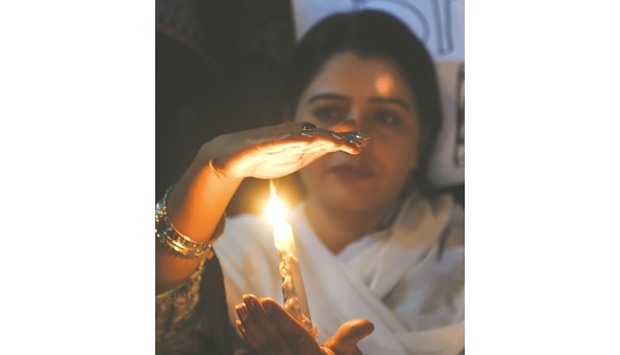 VIGIL: An activist lighting a candle during a vigil in Karachi in homage to the victims of a suicide attack on the shrine of Sufi saint Lal Shahbaz Qalandar. u2014 AFP