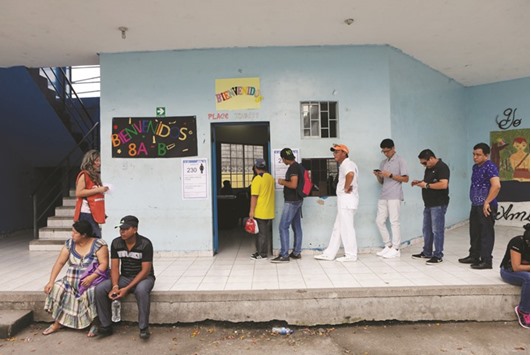 People stand in line to cast their votes during the presidential election at a school-turned-polling station in Guayaquil, Ecuador, yesterday.