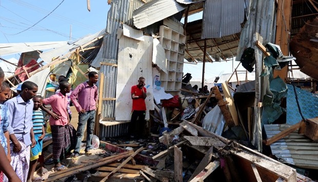 Traders look at a stall destroyed at the scene of a suicide bomb explosion at the Wadajir market in Madina district of Somalia's capital Mogadishu.