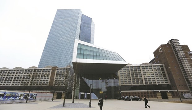 People walk in front of the European Central Bank headquarters in Frankfurt. The ECB is in a complex predicament, having to justify why the euro area still needs unprecedented stimulus even with headline inflation near its goal and the economy continuing to expand.