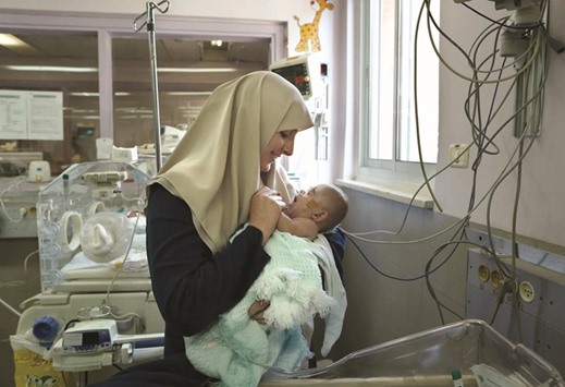 Gazan Jumana Daoud carries her seven-month-old daughter Maryam at Makassed Hospital in east Jerusalem yesterday, as they meet for the first time since the babyu2019s premature birth.