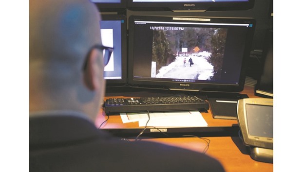A telecommunications operator reenacts procedure for an illegal US-Canada border crossing seen in their operational control centre at Royal Canadian Mounted Police headquarters in Montreal.