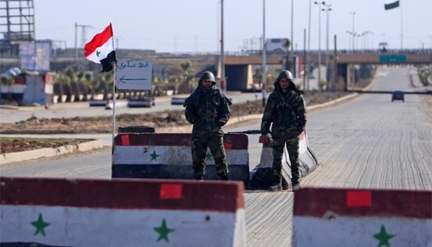 Syrian army soldiers man a checkpoint along a road in Aleppo on Wednesday.