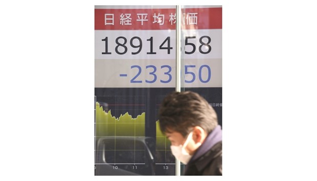 A businessman walks in front of the electronic stock indicator flashing the closing rate of the Tokyo Stock Exchange. The benchmark Nikkei 225 index dipped 1.22%, or 233.50 points, to close at 18,914.58 hit by a stronger yen and concerns about the outlook for the global economy under a Donald Trump presidency.