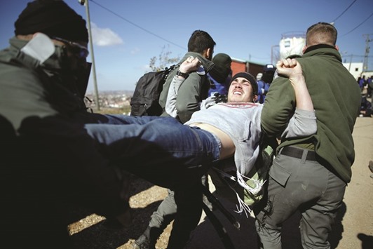 Israeli policemen remove a pro-settlement activist yesterday during an operation to evict settlers from the illegal outpost of Amona in the occupied West Bank.