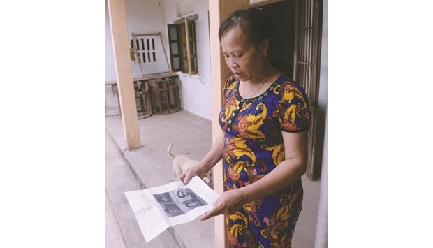 Nguyen Thi Vy, mother-in-law of Doan Thi Huong, a suspect involved in the assassination of Kim Jong-unu2019s half-brother, looks at handouts and published photographs of the four arrested suspects including Huong at Huongu2019s family home in Nghia Hung district, northern province of Nam Dinh, Vietnam.