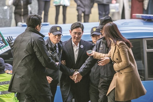 Jay Y Lee, co-vice chairman of Samsung Electronics (centre), is escorted by officers as he arrives at the special prosecutorsu2019 office in Seoul on February 18. The case against Lee, who hasnu2019t been formally indicted, hasnu2019t advanced, with both Samsung and Lee denying he did anything wrong. Yet the conditions of his confinement show how serious the consequences of the investigation have been so far.