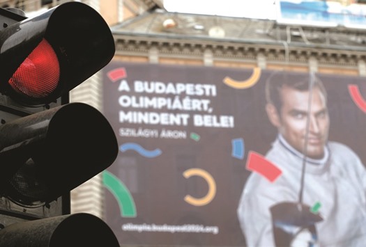 Traffic lights switch to red in front of a Hungarian pro-Olympics billboard with two-times sabre fencing Olympic champion Aron Szilagyi advertising the Games, billboard saying u201cGive it all for the Budapest Olympicsu201d in central Budapest. (Reuters)