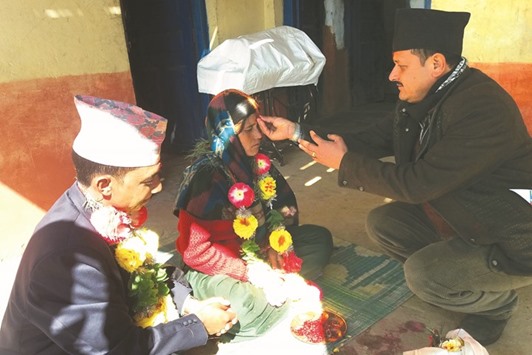 Prisoners Dilli Koirala, left, and Mimkosha Bista are blessed by an official, right, as they take part in their wedding ceremony inside Kalikot district jail in Kalikot, some 388km from Kathmandu.