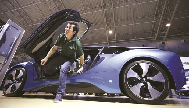 A visitor gets out of a new BMW i8 plug-in hybrid sports car during the Auto China 2016 in Beijing. German imports from and exports to China rose to u20ac170bn ($180bn) last year, Federal Statistics Office figures showed yesterday.
