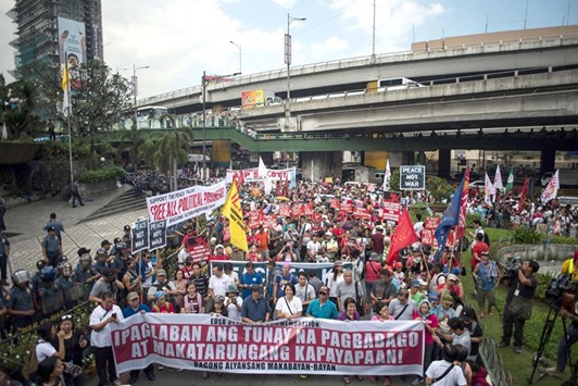 Activists march on the Edsa highway on their way to protest President Rodrigo Duterteu2019s brutal war on drugs, in front of the Armed Forces of the Philippines (AFP) headquarters in Manila yesterday, during the 31st anniversary of the u201cPeople Poweru201d revolution.