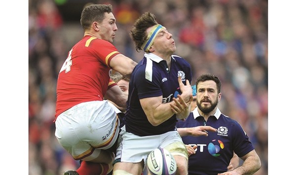 Walesu2019 wing George North (L) vies with Scotlandu2019s Hamish Watson (C) during their Six Nations international rugby union match at Murrayfield in Edinburgh yesterday.