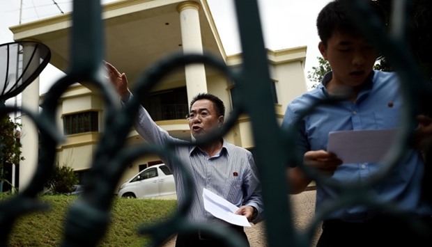 North Korean Embassy counsellor Kim Yu Song (L) gestures while reading a statement to journalists waiting outside the North Korean embassy in Kuala Lumpur on February 24, 2017