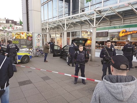 Police officers stand around the car that was driven into pedestrians in front of a business building in Heidelberg, western Germany.