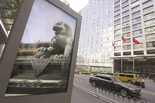 An advertising board (left) showing a Chinese stone lion pictured near an entrance to the headquarters (right) of China Securities Regulatory Commission (CSRC), in Beijing. China will allow more companies to list on its stock market to boost support for its economy, the nationu2019s top securities regulator said, dismissing concerns that more supplies of shares can depress the market.