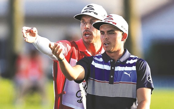 Rickie Fowler of the United States talks with his caddie Joe Skovron during the third round of the Honda Classic, in Palm Beach Gardens, Florida, on Saturday. (AFP)