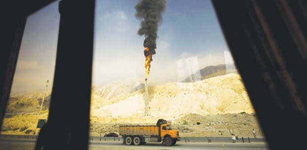A gas flame is seen through a bus window in the South Pars gas field facilities in the southern Iranian port of Assaluyeh (file). The country may need as much as $100bn to develop its gas business, but estimates vary widely.