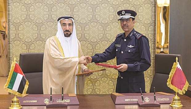Director General of Public Security Staff Major General Saad bin Jassim al-Khulaifi and UAEu2019s Undersecretary of the Ministry of Interior Lt General Saif Abdullah al-Shafar exchange documents after signing an agreement in the field of u2018passportu2019.